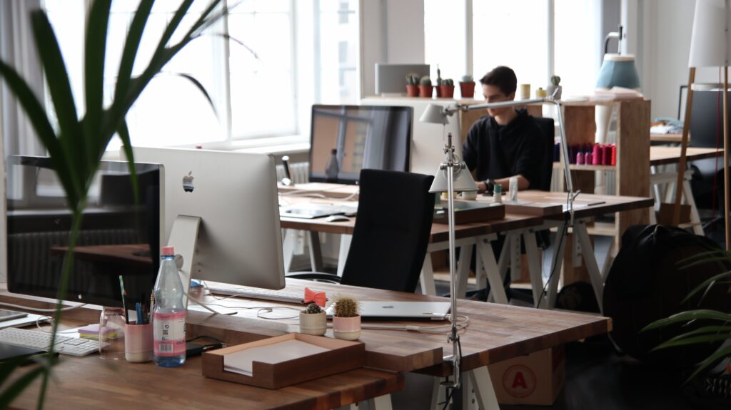 photo of an office with desks, computers, and one person in the far orner.